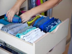 A organized clothes on a cabinet.