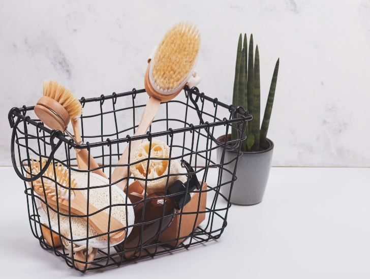 A metal basket on the bathroom with toilettries. 