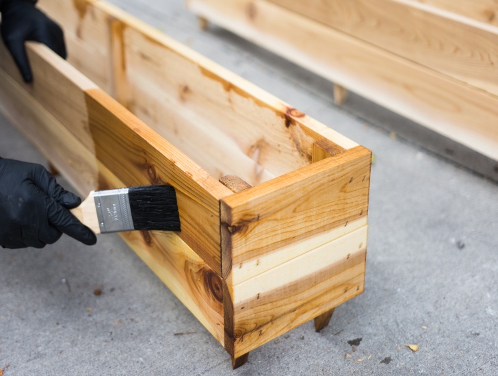 A wooden box being varnished. 