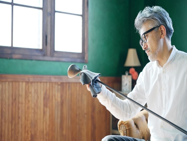 A adult cleaning a golf club.
